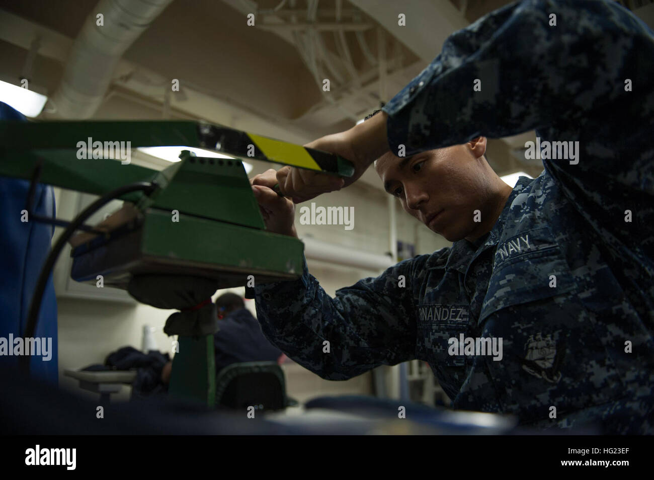 Luftfahrt Maschinist Mate Airman Gustavo Hernandez, zugewiesene amphibische Schiff USS America (LHA-6), klemmt einen einheitliche Patch, bereitet sie auf ein paar schwer entflammbar Variante Overalls genäht werden. Amerika ist das erste Schiff seiner Klasse und die vierte den Namen tragen. Das Schiff wird die Tarawa-Klasse der amphibischen Angriff Schiff wie die nächste Generation "groß-Deck" amphibischer Angriff Schiff und ist optimiert für die Luftfahrt und in der Lage, aktuelle und zukünftige Flugzeuge wie die MV-22 Osprey und F-35 b Joint Strike Fighter ersetzt. (Foto: U.S. Navy Mass Communication Specialist 2. Klasse Ry Stockfoto