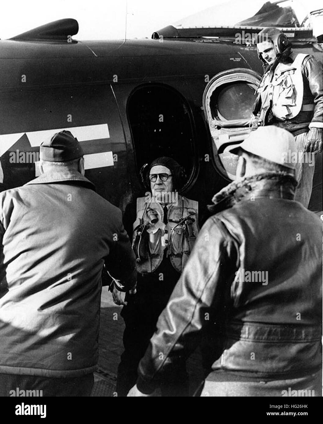 Secretary Of The Navy Francis P. Matthews (Mitte) steigt aus einem Douglas AD-4N Skyraider Flugzeug nach geflogen an Bord USS Philippine Sea (CV-47) aus Korea, 22. November 1950. Er wird von der Fluggesellschaft befehlshabender Offizier, Captain Willard K. Goodney begrüßt werden. Sekretärin Matthews besuchte Marine Einheiten Koreakrieg Operationen beteiligt. Beachten Sie seine Leder Flug Helm und aufblasbare Schwimmweste.  Offizielle US-Navy, Foto, jetzt in den Sammlungen der National Archives. US-SecNav Matthews an Bord USS Philippine Sea (CV-47) im Jahr 1950 Stockfoto