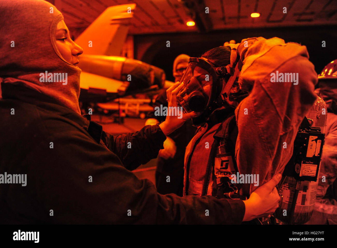 150605-N-KU391-023 USA 5TH Flotte AREA OF OPERATIONS (5. Juni 2015)-Personal Spezialist Seemann Jennifer Dicostanzo aus Houston, unterstützt Yeoman 3. Klasse Tiare Santana aus Waiane, Hawaii, kleiden während eine allgemeine Viertel Bohrer im Hangar des Flugzeugträgers USS Theodore Roosevelt (CVN-71) Bucht. Theodore Roosevelt wird in den USA 5. Flotte Einsatzgebiet unterstützen Betrieb innewohnende zu beheben, Streik Operationen im Irak und in Syrien, wie verwiesen, maritime Sicherheit und Theater Sicherheitsbemühungen Zusammenarbeit in der Region bereitgestellt. (U.S. Navy Photo von Masse Kommunikation besondere Stockfoto