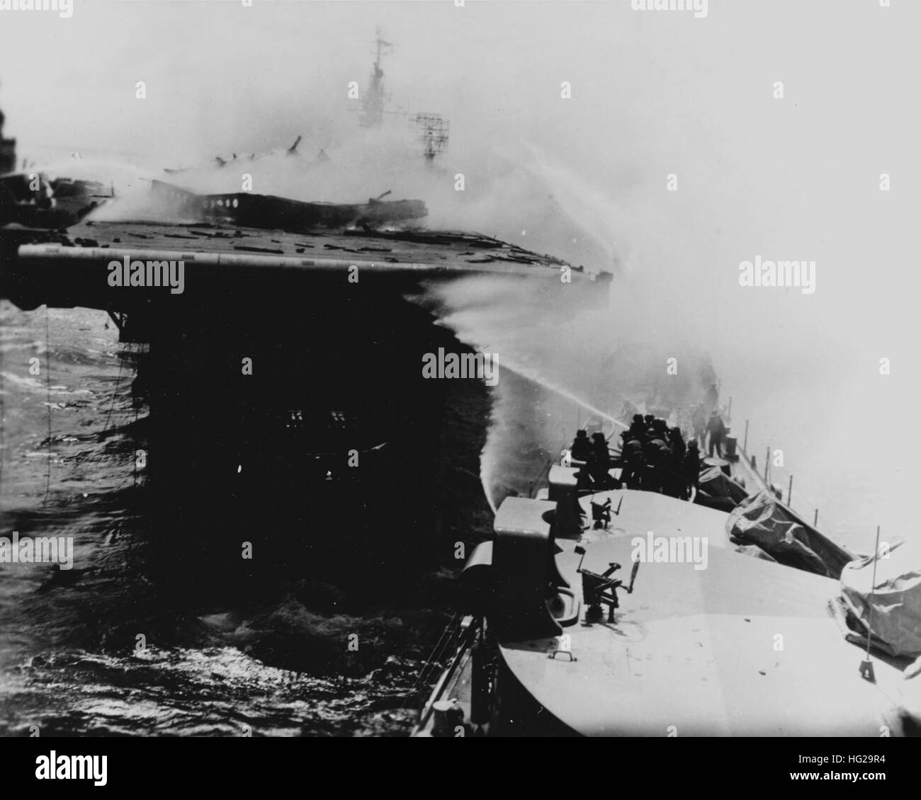 USS Reno (CL-96) steht ab dem Steuerbord Quartal USS Princeton (CVL-23), bei der Bekämpfung von Bränden an Bord der zerbombten Träger, 24. Oktober 1944. Hinweis Reno nach vorne 5/38 Twin Gewehr Reittiere im Vordergrund, mit lokalen Feuerkontrolle Sehenswürdigkeiten an der Spitze. Offizielle US-Navy, Foto, aus den Sammlungen der Marine-Geschichte und Erbe-Befehl. USS Reno Brandbekämpfung auf USS Princeton Stockfoto