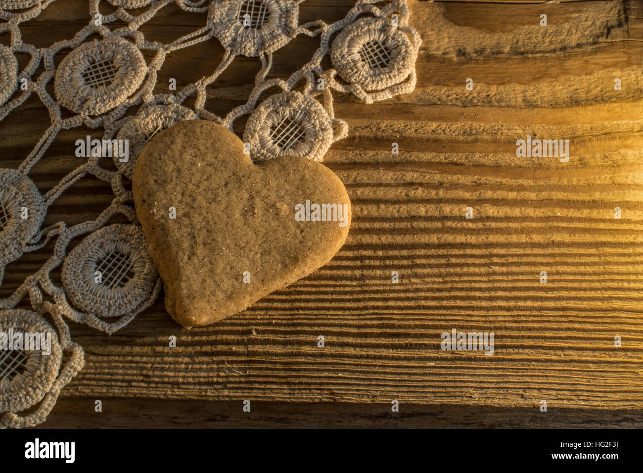 Cookie mit Herz. auf der gestrickten Tischdecke und Holztisch Stockfoto