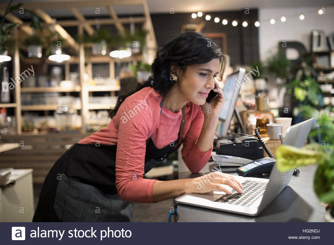 Weibliche Shop-Betreiber arbeiten am Laptop an Anlage Ladentheke Stockfoto