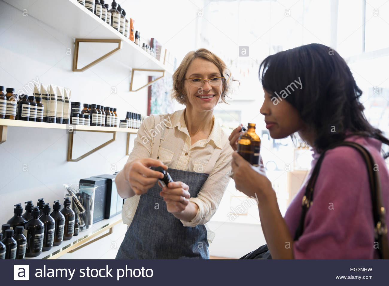 Weibliche Shop Besitzer helfen Frau riecht nach Hause Düfte im shop Stockfoto