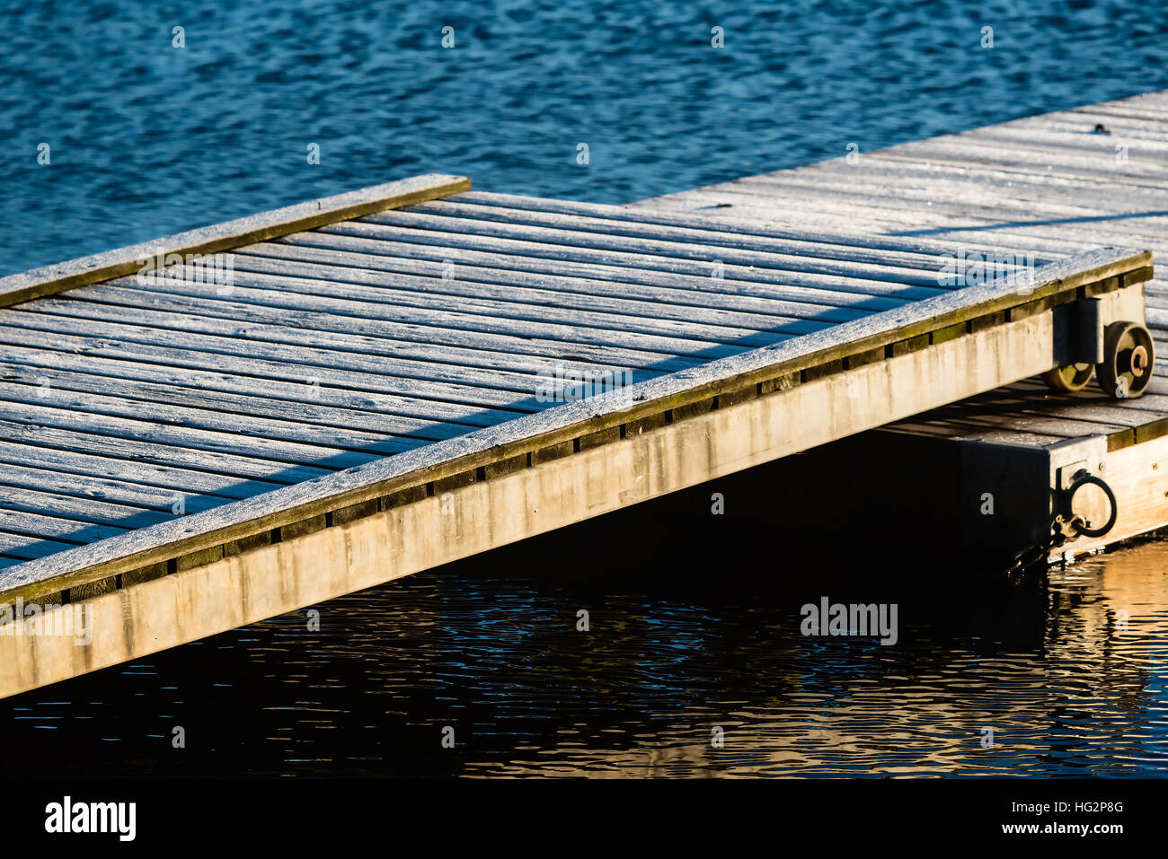 Kalter Morgen am Meer. Frost bedecken die hölzerne Pier Überlappung, die Bewegung ermöglicht wie der Schwimmsteg bewegt sich mit wechselnden Wasserständen. Stockfoto