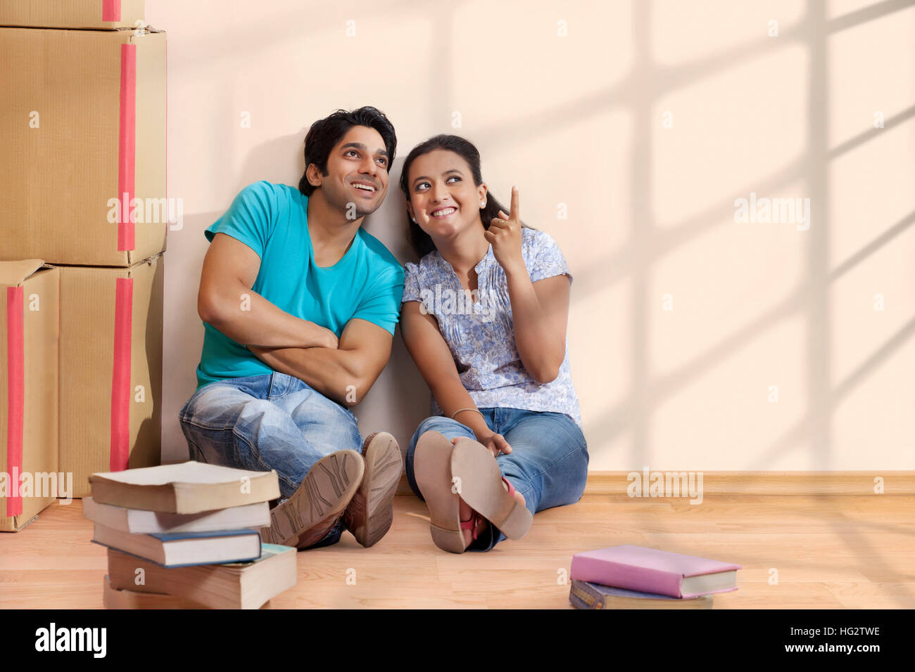 Glückliches Paar zeigte mit dem Finger etwas im neuen Zuhause zu zeigen Stockfoto