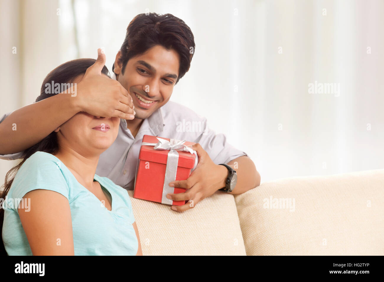 Mann, eine Frau mit einem Geschenk zu überraschen Stockfoto