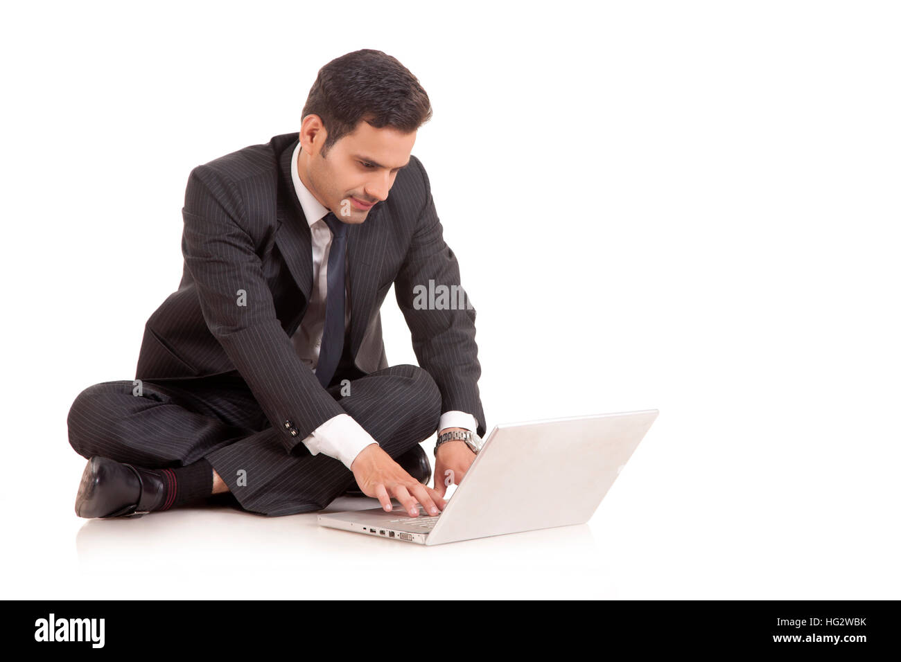Unternehmer sitzen auf dem Boden und arbeitet mit seinem Laptop. Auf weissem Hintergrund Stockfoto Unternehmer sitzen auf dem Boden und arbeitet mit seinem Laptop. Auf weissem Hintergrund Stockfoto