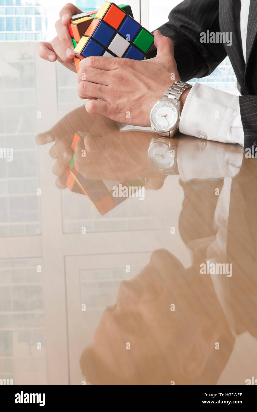 Geschäftsmann holding Rubik's Cube in seinen Händen Stockfoto