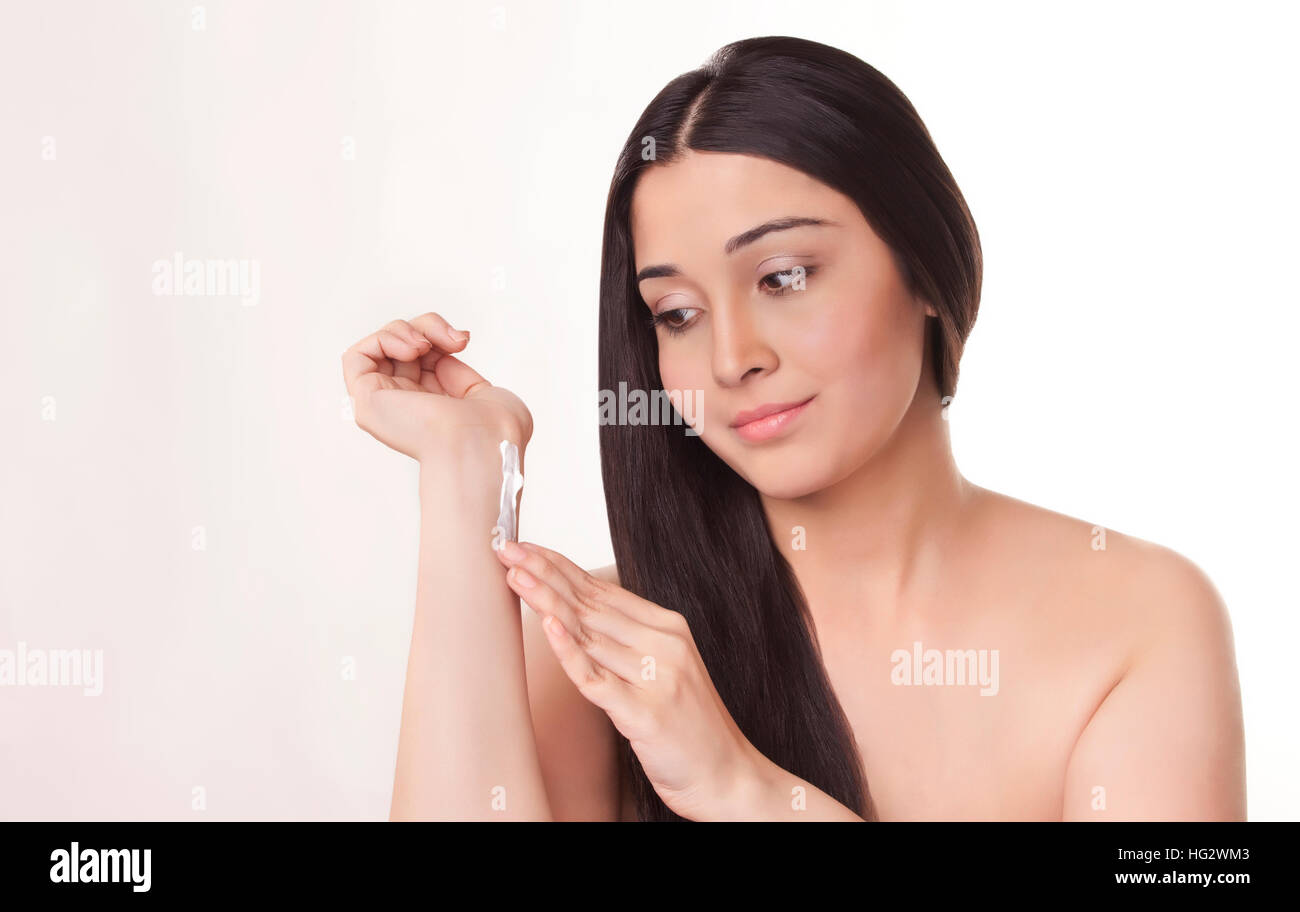 Junge Frau Anwendung die Creme auf die Hand Stockfoto