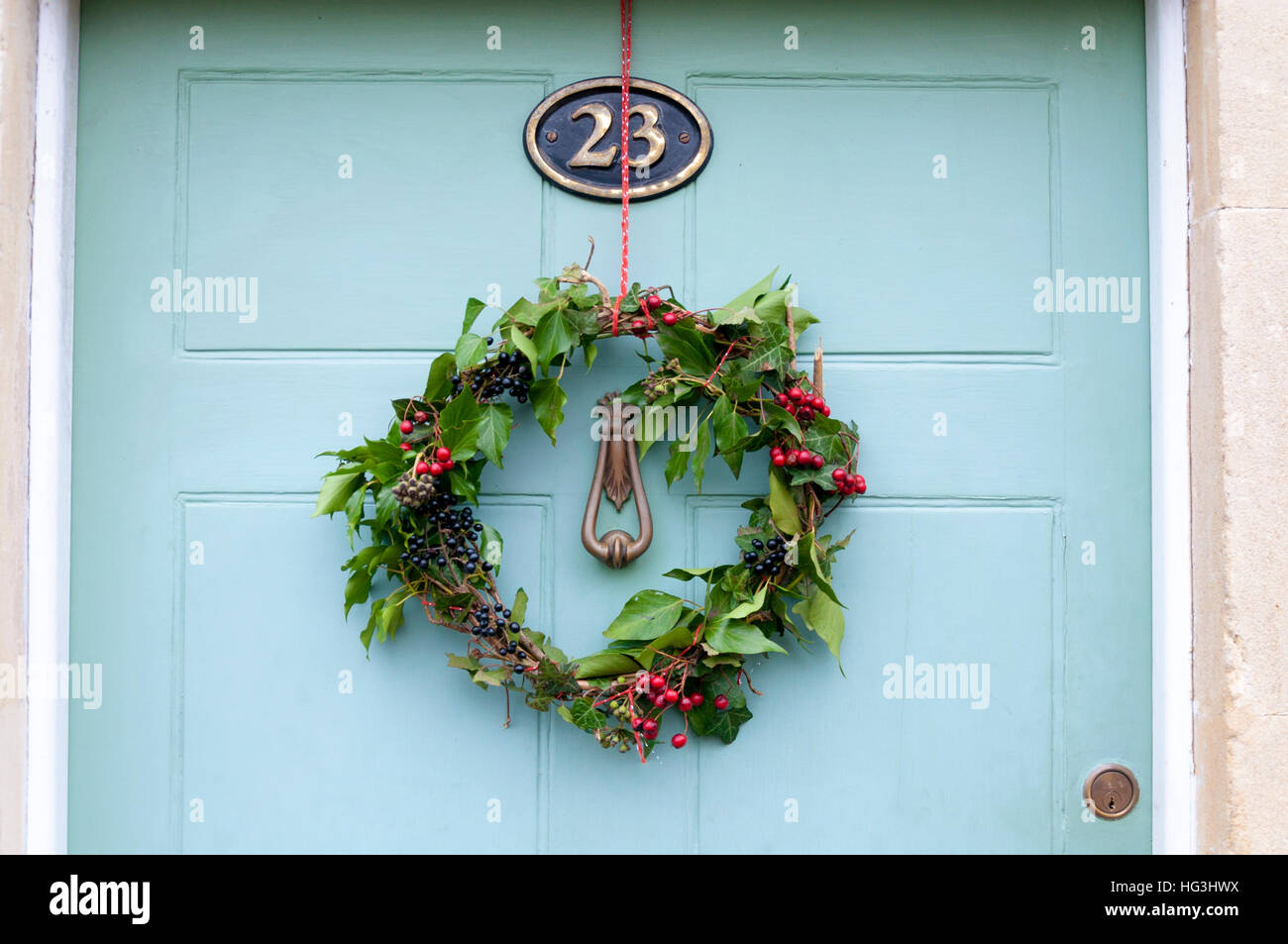 Weihnachtskranz an der Haustür aufhängen Stockfoto
