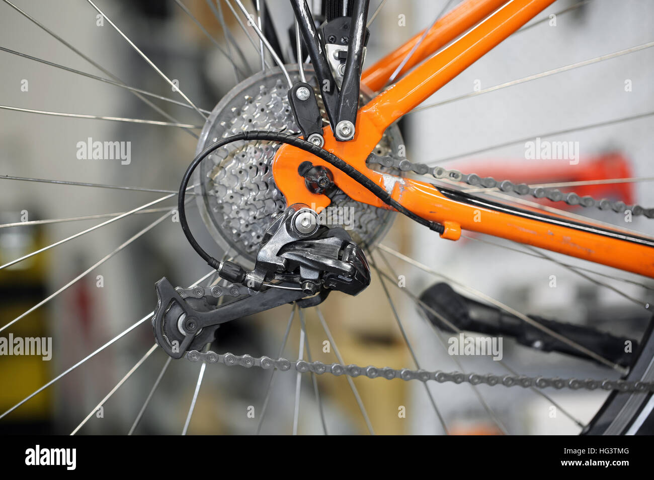 Detail einer Kette Ringe und hinteren Schaltwerk eines orange Bikes Stockfoto