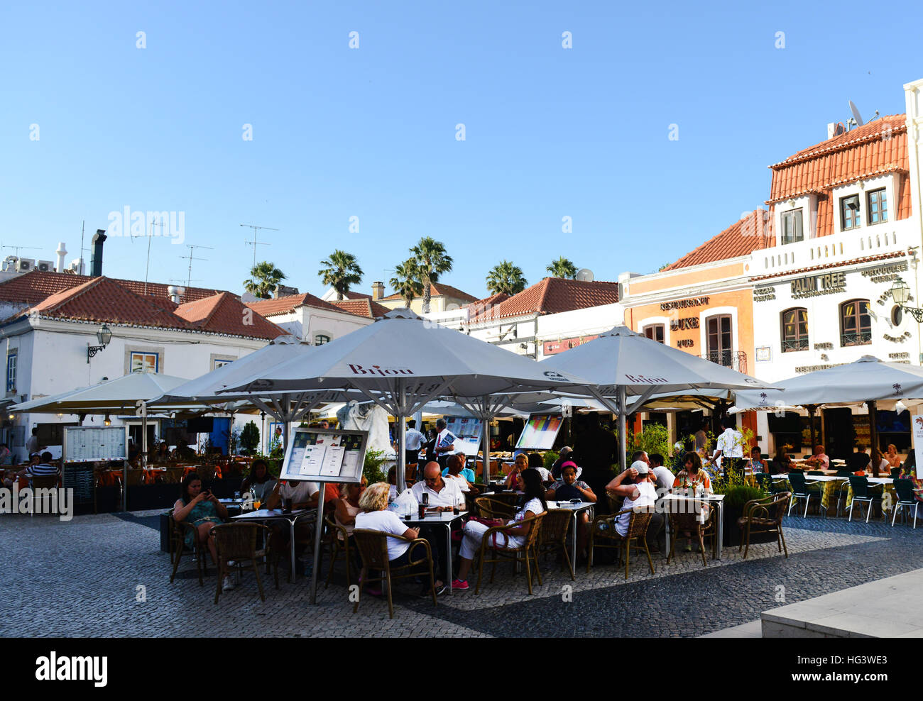 Touristen sitzen in einem Straßencafé / Restaurant in Cascais, Portugal. Stockfoto