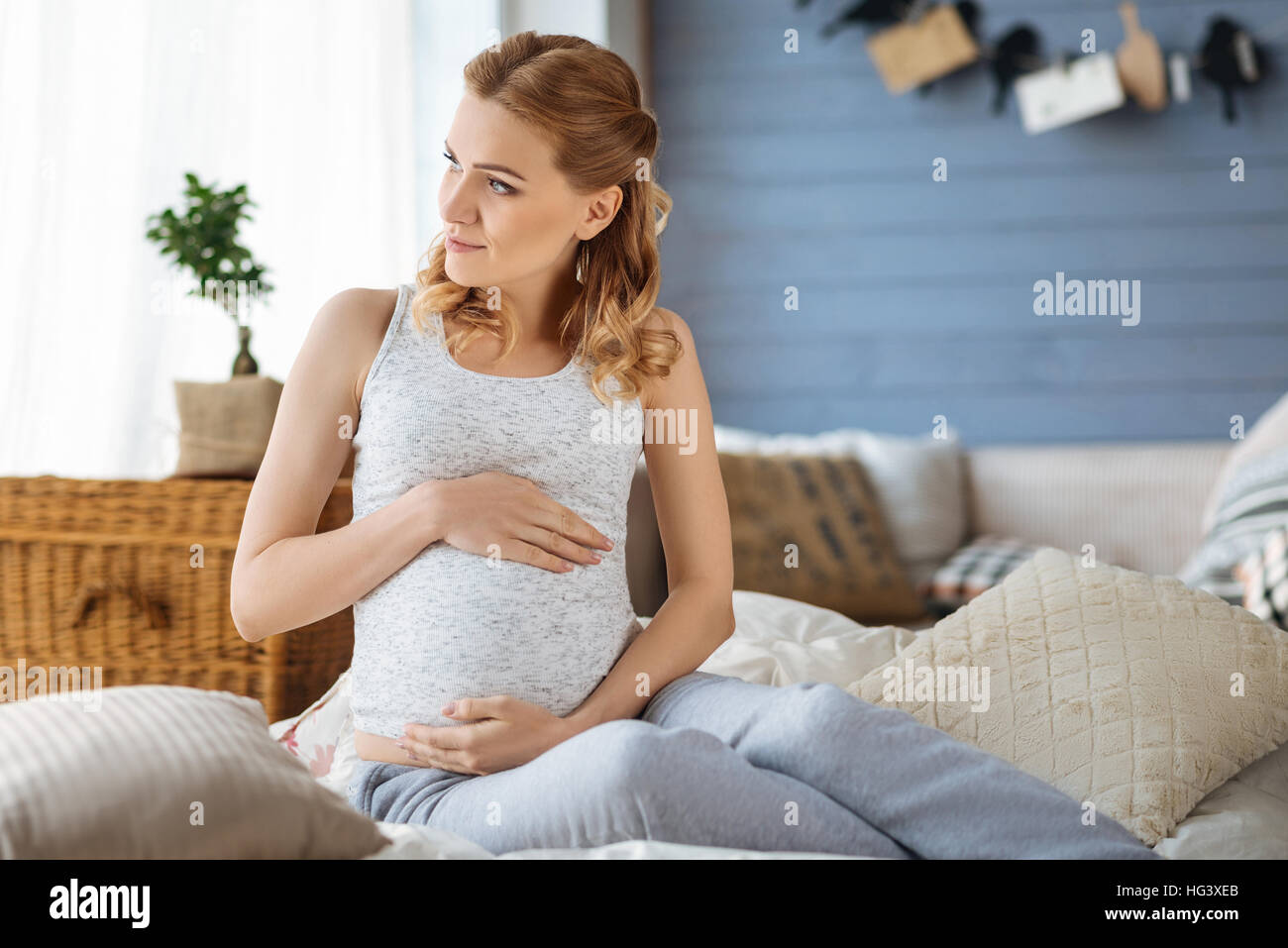 Schwangere Frau entspannend in einem Schlafzimmer Stockfoto