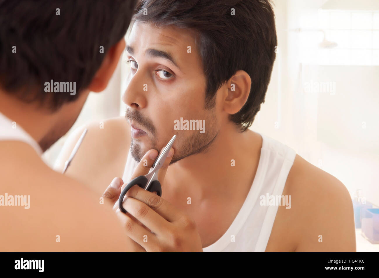 Man grooming seinen Bart mit der Schere Stockfoto