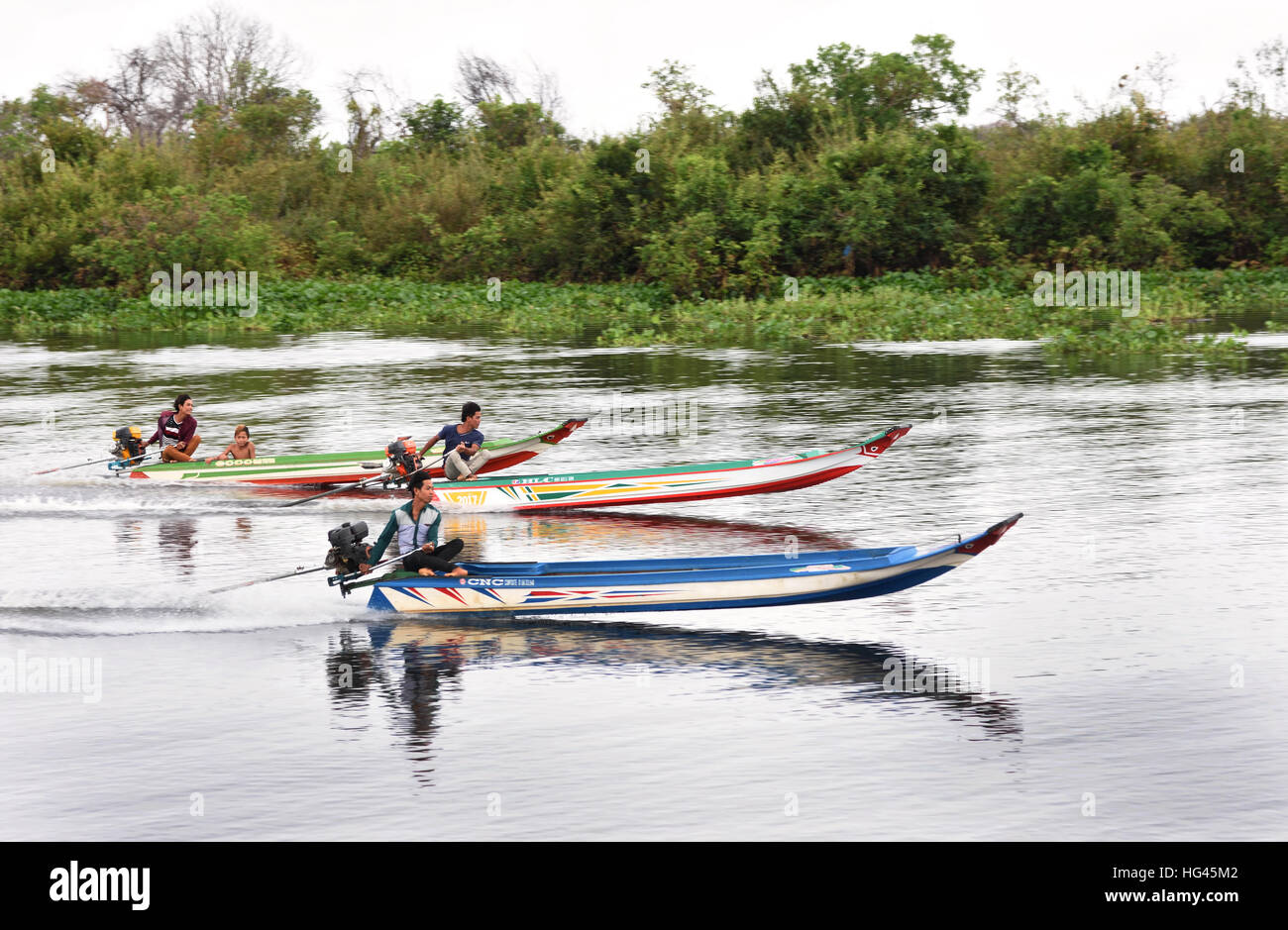 Bootsrennen junge Männer auf der Sangkhae - Sangker River Battambang Provinz Cambodia.The Tonle Sap Frischwasser See (reichsten See zum Angeln in der Welt) fließt in den Mekong in Phnom Penh.  Die kambodschanische Bevölkerung hat auch für das einzigartige Ökosystem des Sees mit schwimmenden angepasst (Fischer-Fischerei) Dörfer und gestelzt Häuser. Stockfoto