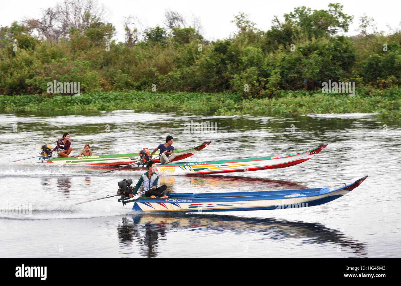 Bootsrennen junge Männer auf der Sangkhae - Sangker River Battambang Provinz Cambodia.The Tonle Sap Frischwasser See (reichsten See zum Angeln in der Welt) fließt in den Mekong in Phnom Penh.  Die kambodschanische Bevölkerung hat auch für das einzigartige Ökosystem des Sees mit schwimmenden angepasst (Fischer-Fischerei) Dörfer und gestelzt Häuser. Stockfoto