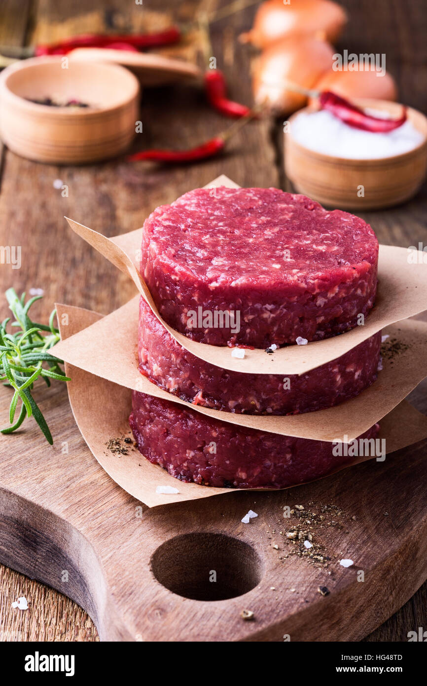 Bio rohes Hackfleisch, runde Fladen für die Herstellung von hausgemachten Burger auf Holzbrett Stockfoto