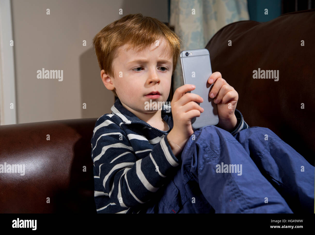 Kind mit Technologie. 5 Jahre alten Jungen mit einem Smartphone oder iPhone Stockfoto