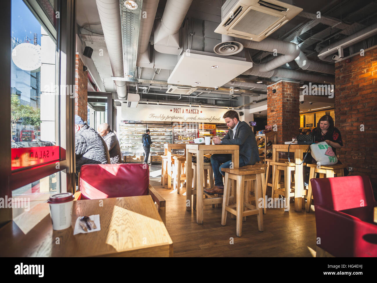 London, Menschen auf dem Tisch, trinken einen Kaffee im Inneren der Pret eine Manager-Café-bar Stockfoto