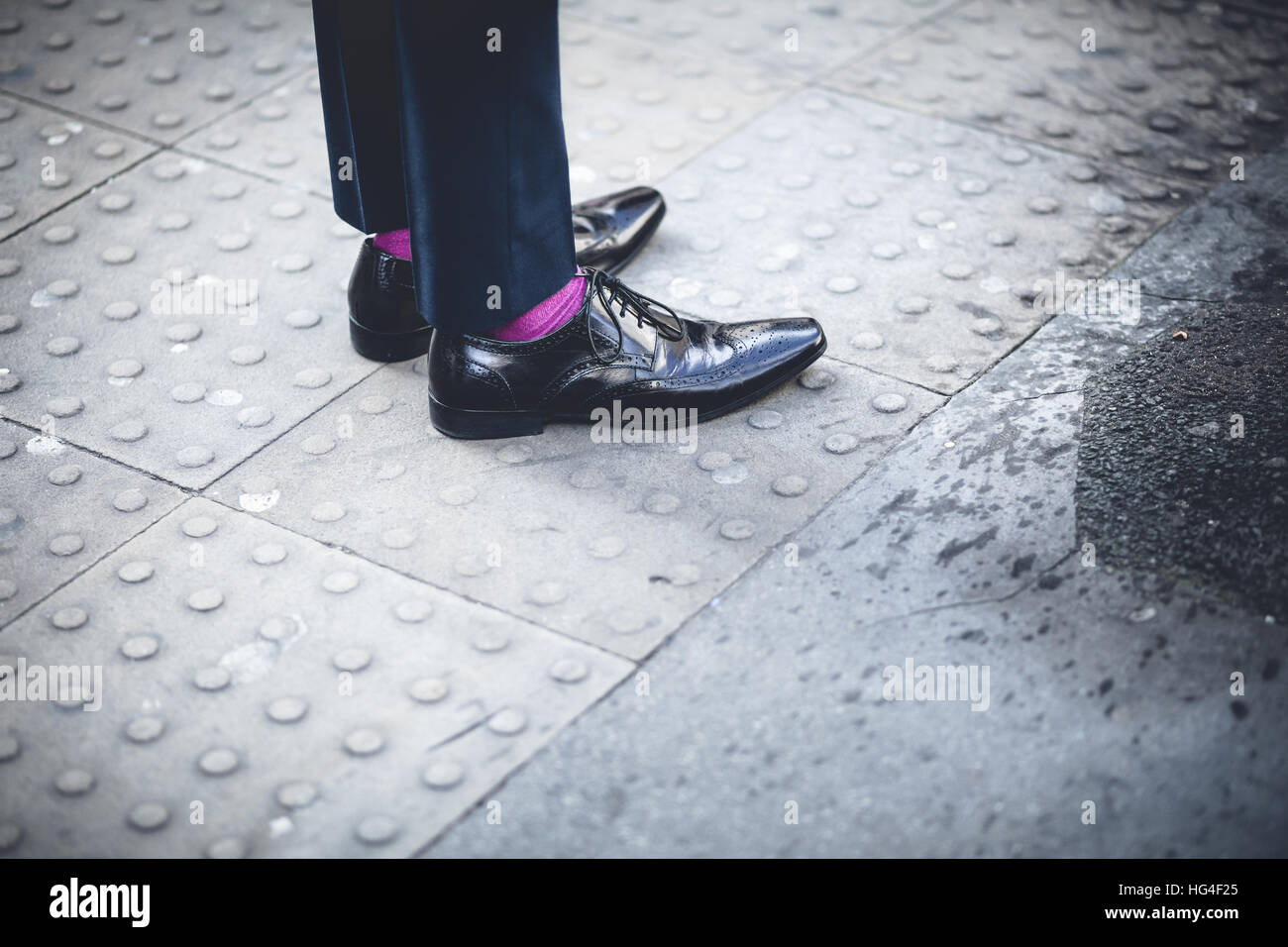 London Fashion street, Mann Beine mit Glanz schwarze Schuhe und lila Socken Stockfoto