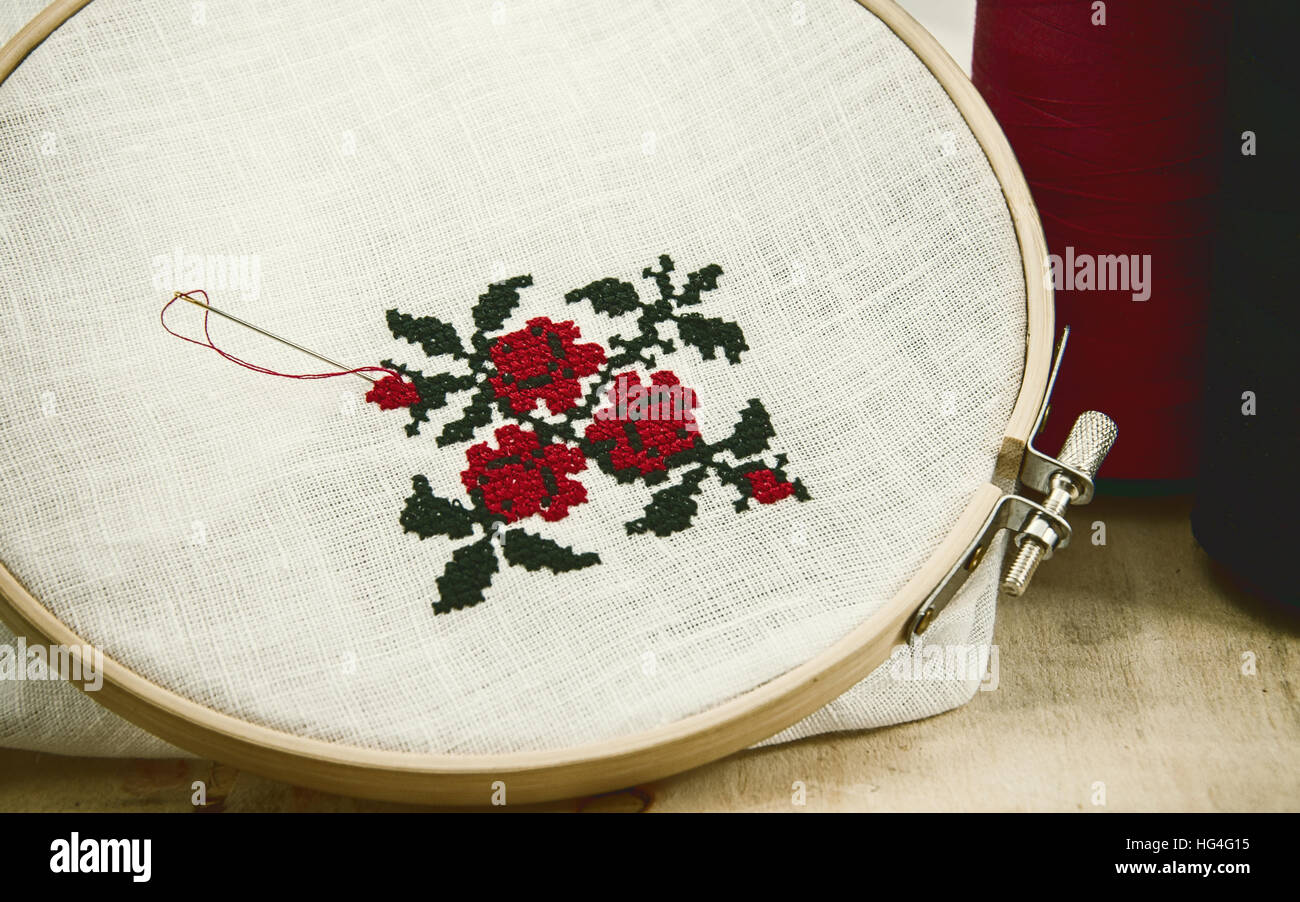 Die Hand Sticken Kreuzstich Blume Ornament auf einem weißen Stoff in den  hölzernen Rahmen rot und schwarz Stickgarn, Vintage Muskelaufbau  Stockfotografie - Alamy