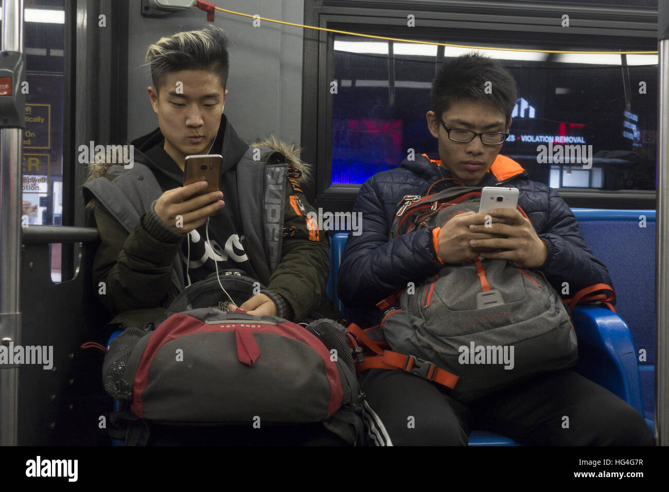 Zwei Asiatische Amerikanische Jugendliche Auf Ihren Handys Wahrend Der Fahrt Mit Eines Offentlichen Bus Am Abend Aus Brooklyn Nach Staten Island Nyc Stockfotografie Alamy