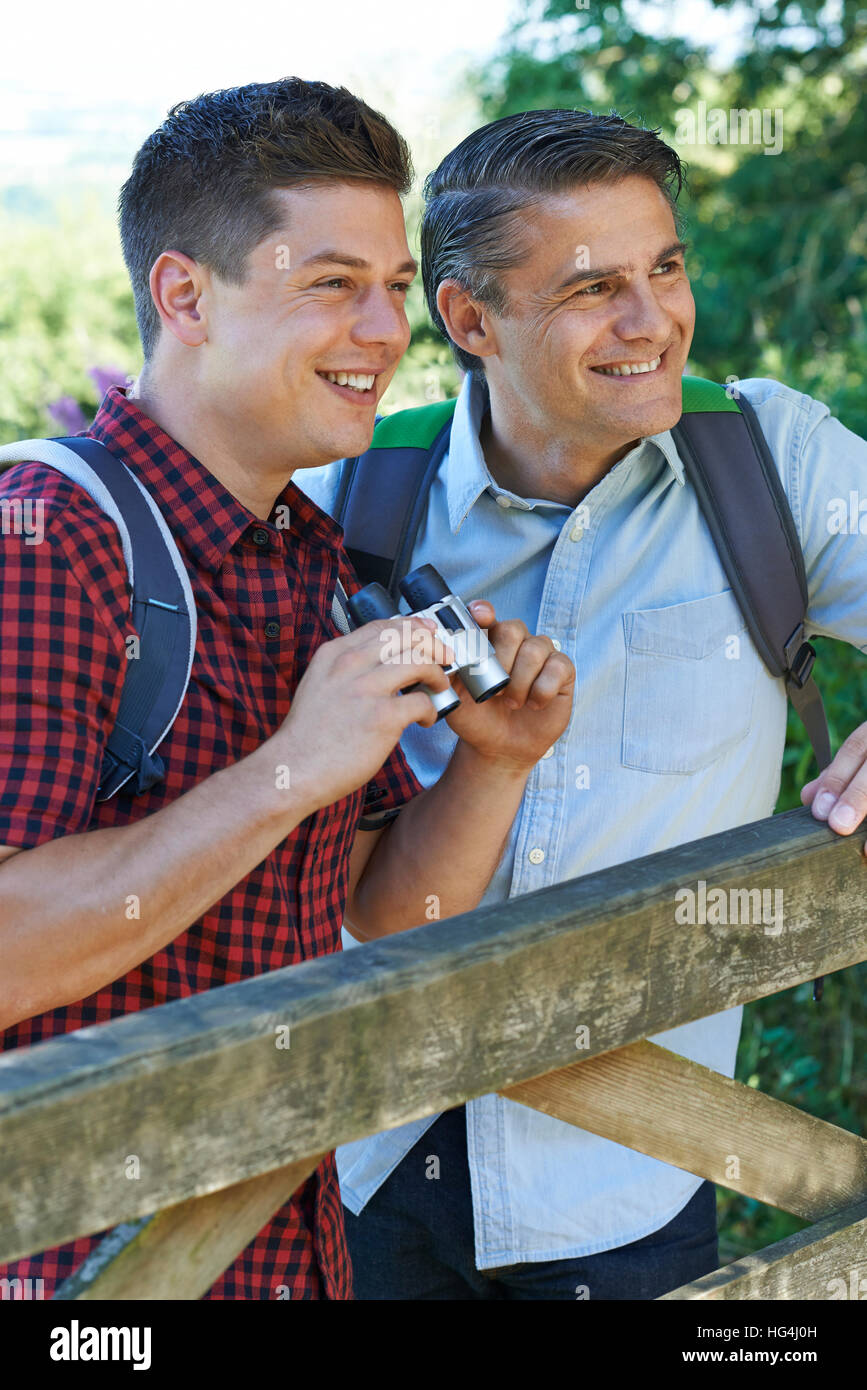 Vater mit erwachsenen Sohn auf Spaziergang In der Natur mit dem Fernglas Stockfoto