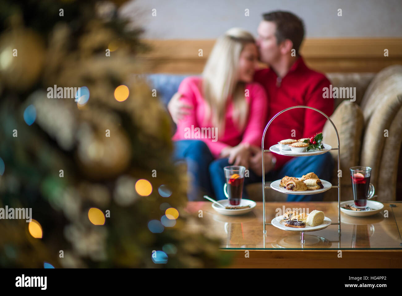 Ein junges Paar zu Weihnachten mit Glühwein auf dem Sofa saß. Stockfoto