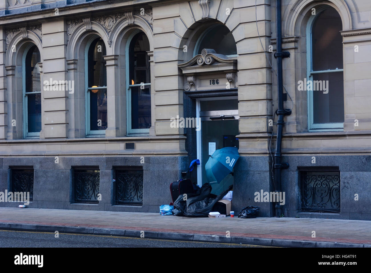 Obdachloser schlafen in einer Tür eines Gebäudes in Deansgate Manchester Stadtzentrum entfernt. Stockfoto