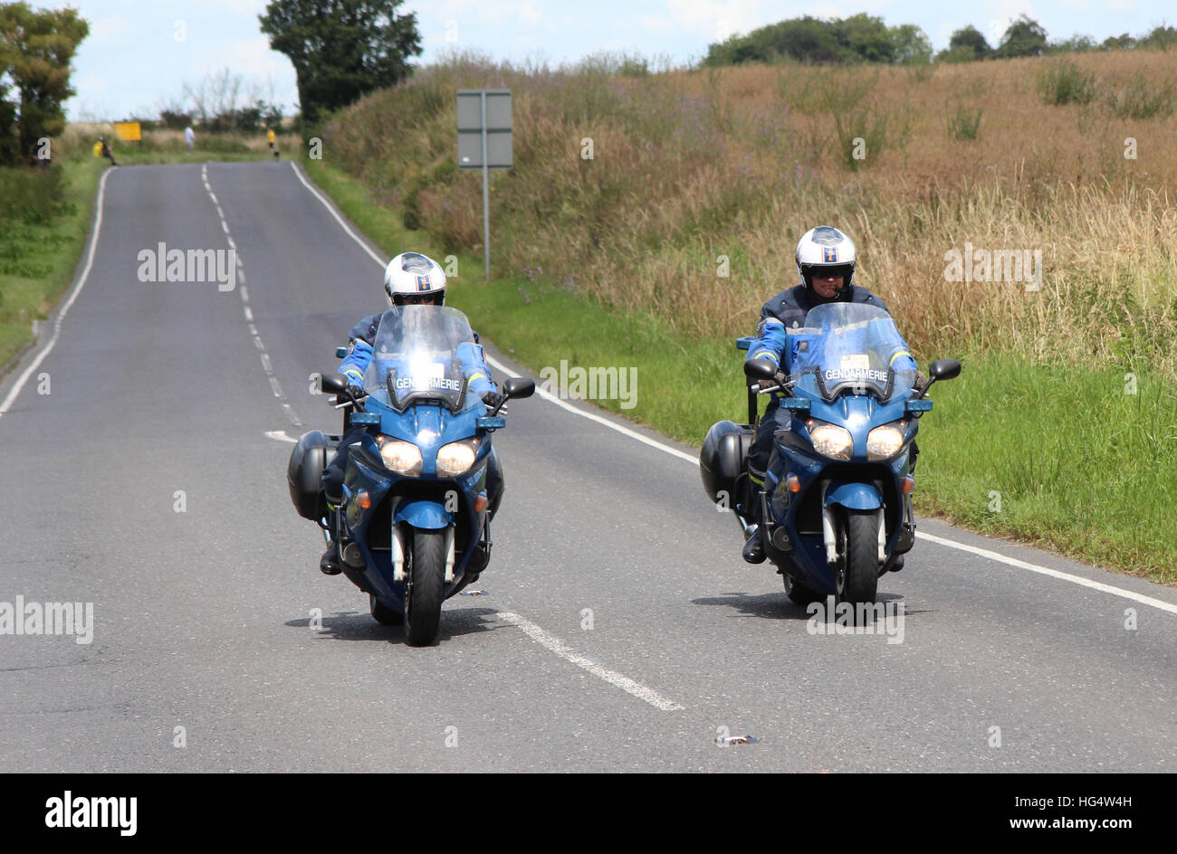 Zwei französische Gendarmerie Motorradfahrer fahren entlang einer britischen Straße in Phase 3 der Tour de France im Jahr 2014. Stockfoto
