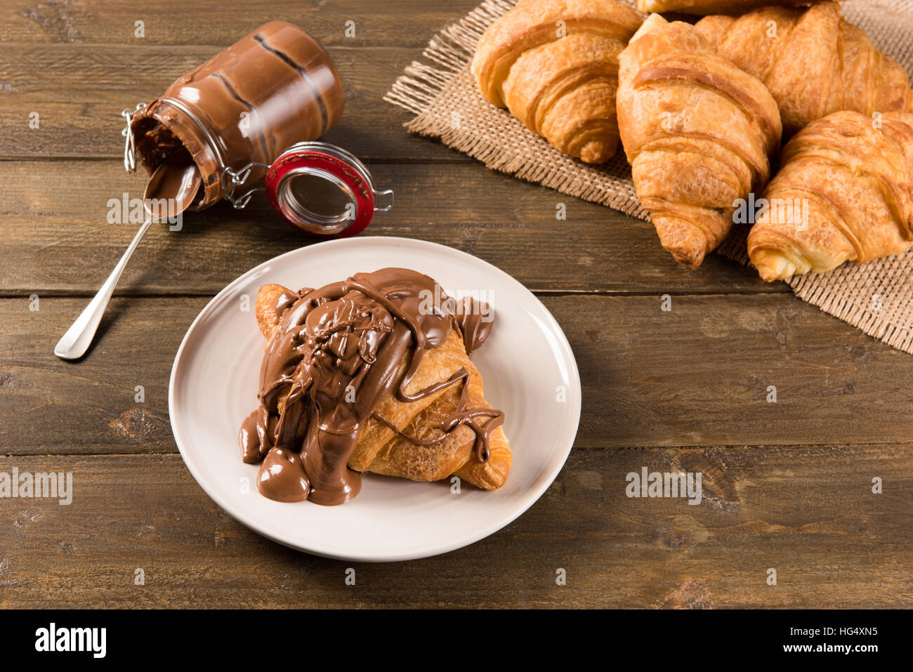 Croissant mit Schokocreme auf dem Tisch in natürlichem Licht Stockfoto Croissant mit Schokocreme auf dem Tisch in natürlichem Licht Stockfoto