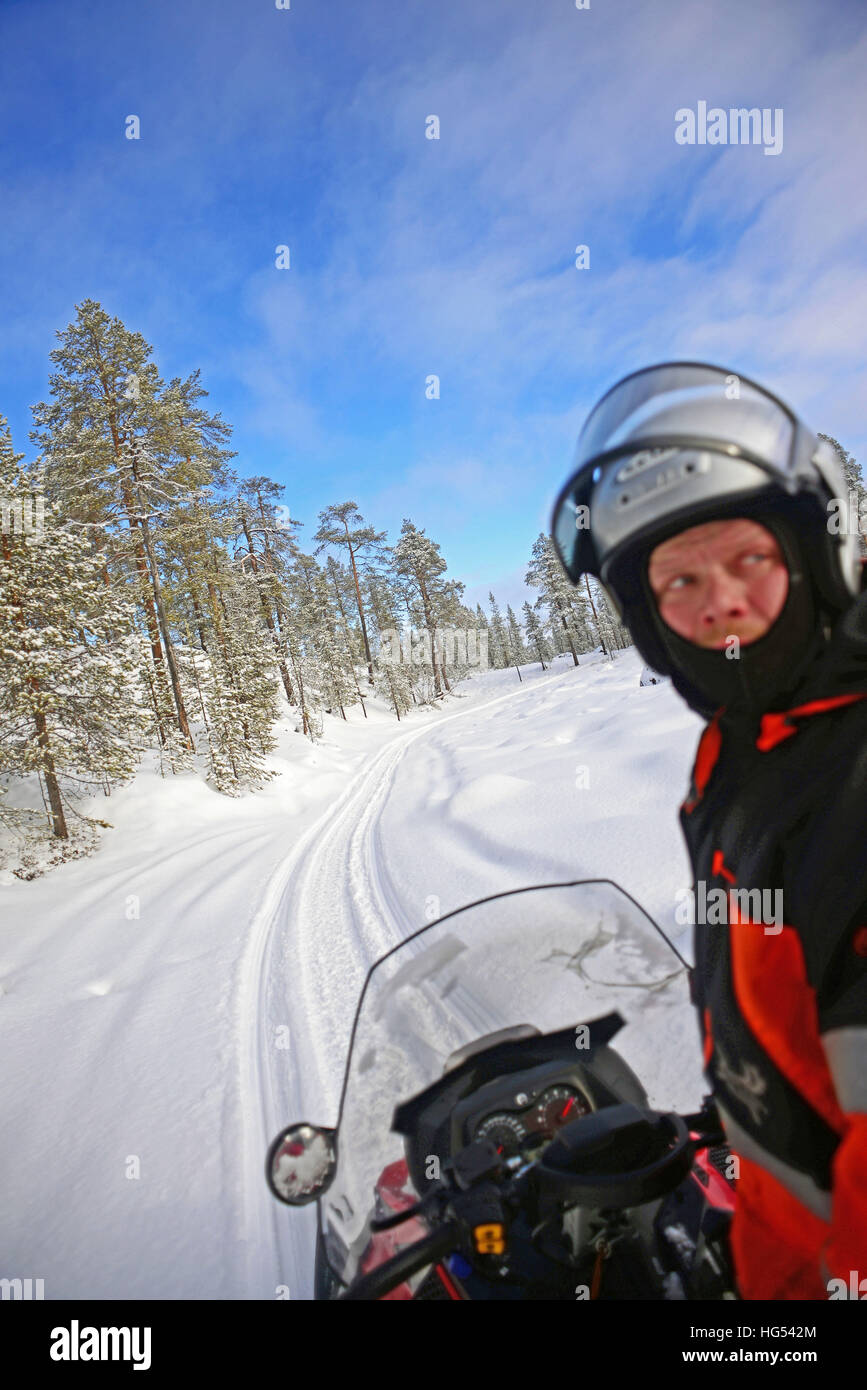 Antti, jungen finnischen Guide von VisitInari, reitet auf einem Schneemobil in der Wildnis von Inari, Lappland, Finnland Stockfoto