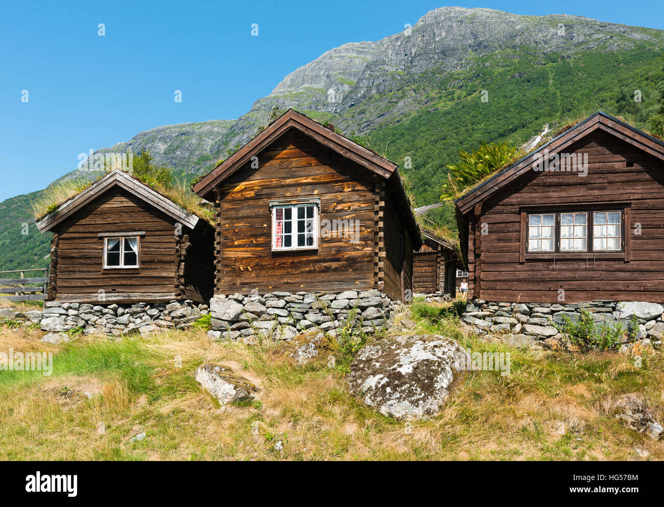 Blick über See Lovatnet, sitzt ein traditionelles norwegisches Haus im Vordergrund mit Sod Dach gekrönt. Stockfoto