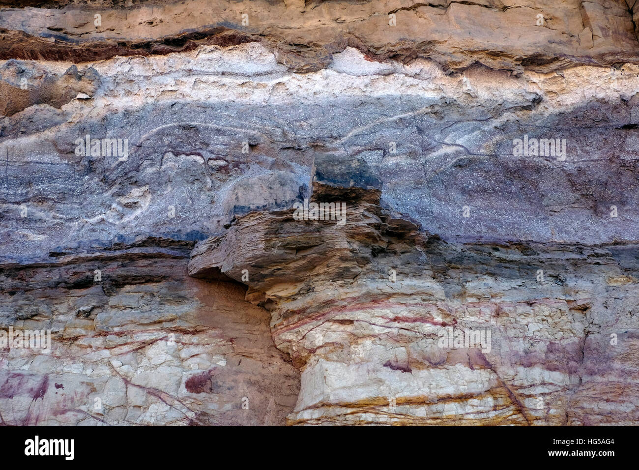 Eine magmatische Deich übergreifende horizontale Schichten von Farbe Bands in ein Sedimentgestein am Wadi Ramon in den äußeren Rand der großen makhtesh Ramon Krater ein geologisches Relief als einzigartig in der Wüste Negev im Süden Israels Stockfoto