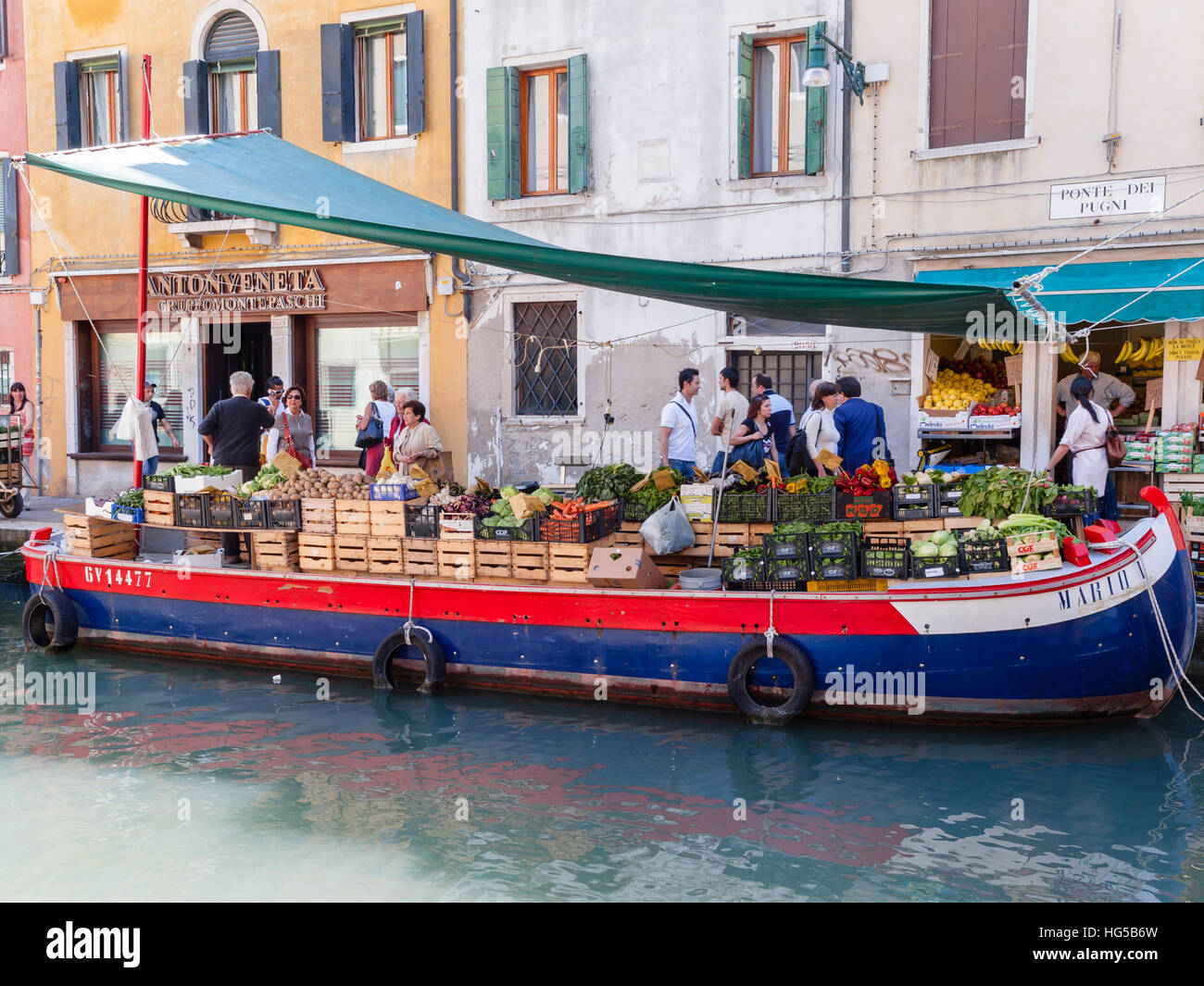 Obst- und Gemüseladen auf einem Lastkahn, der am Kanal in Ponte Dei Pugni, Venedig, Italien, festgemacht ist. Stockfoto