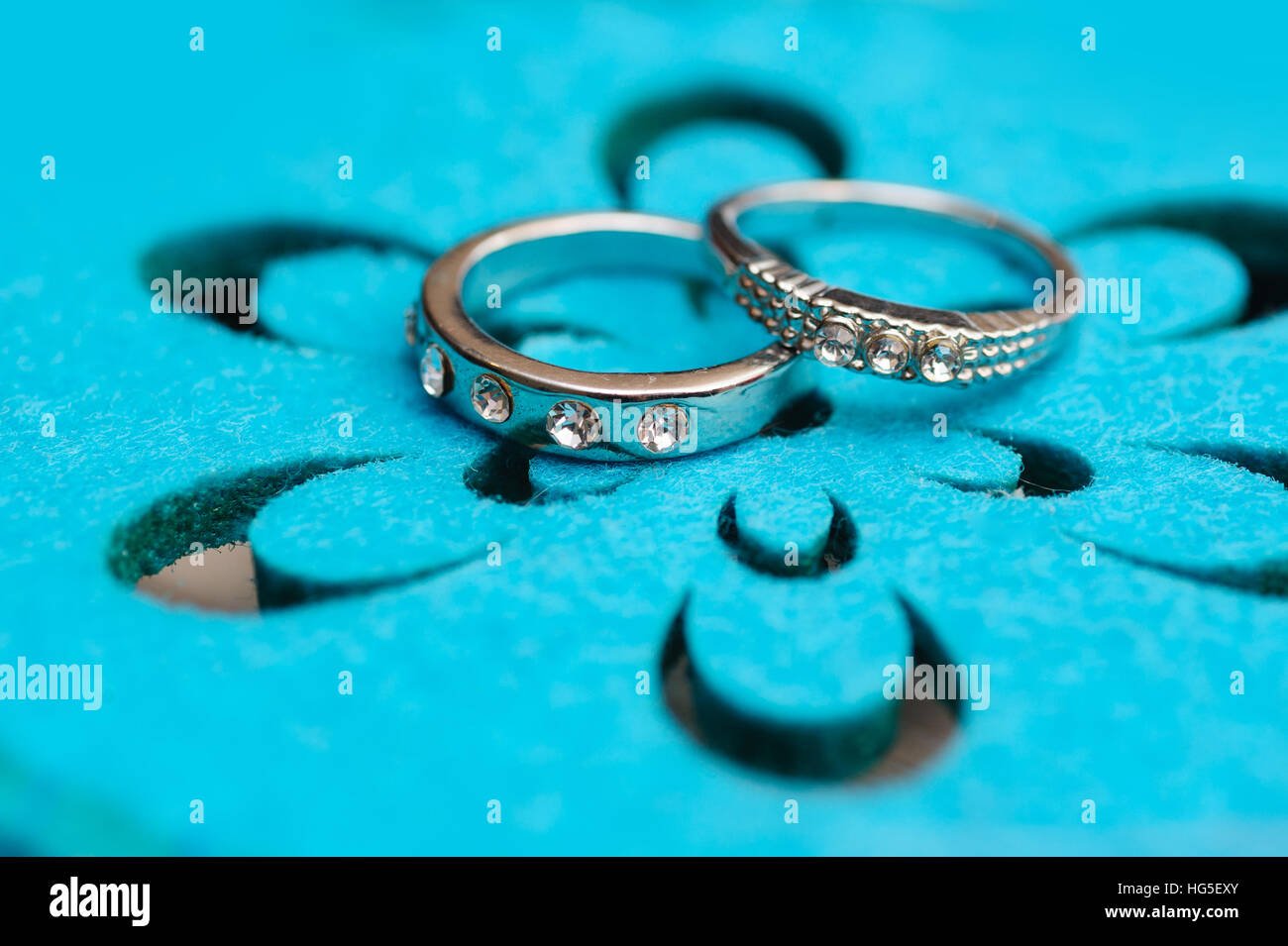 zwei Trauringe Weissgold auf Türkis Hintergrund Stockfoto
