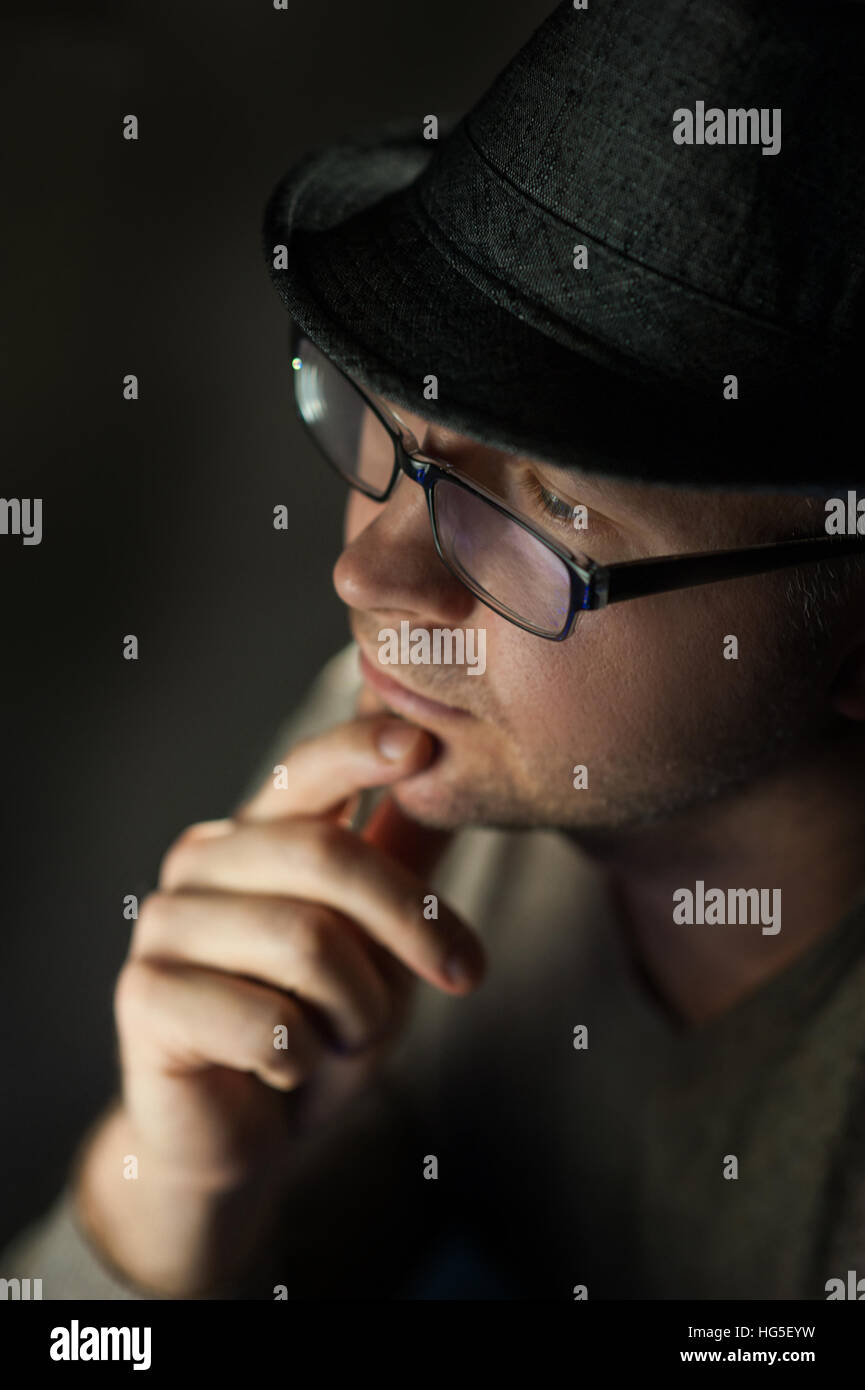 gut aussehender Mann in Hut und Brille posiert Stockfoto
