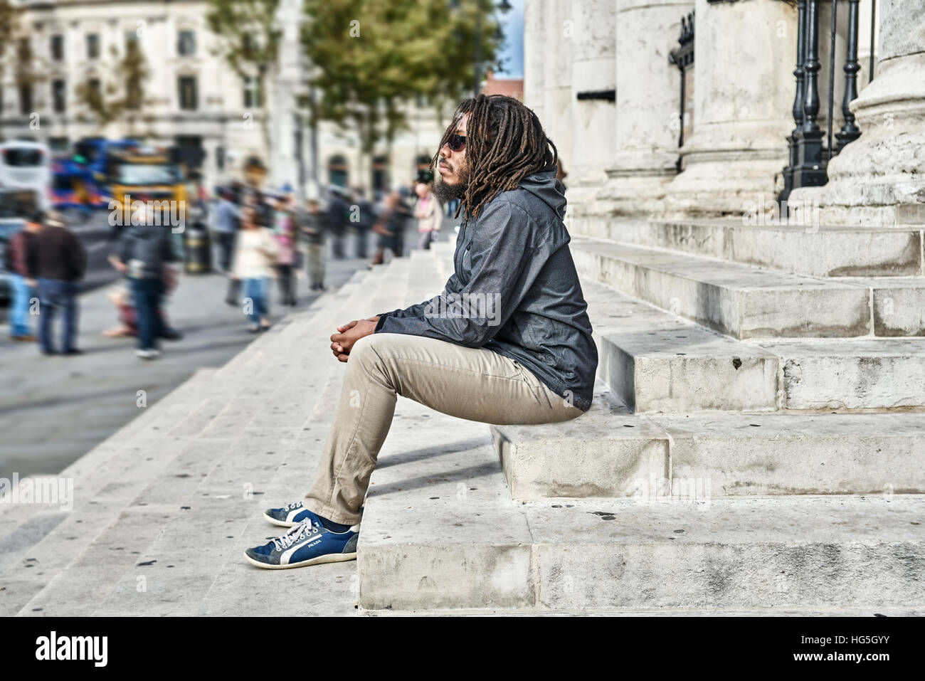 schwarzer Mann.  Mann zu betrachten.   Dreadlocks.  Rastafari.   Allein in der Stadt. Stockfoto