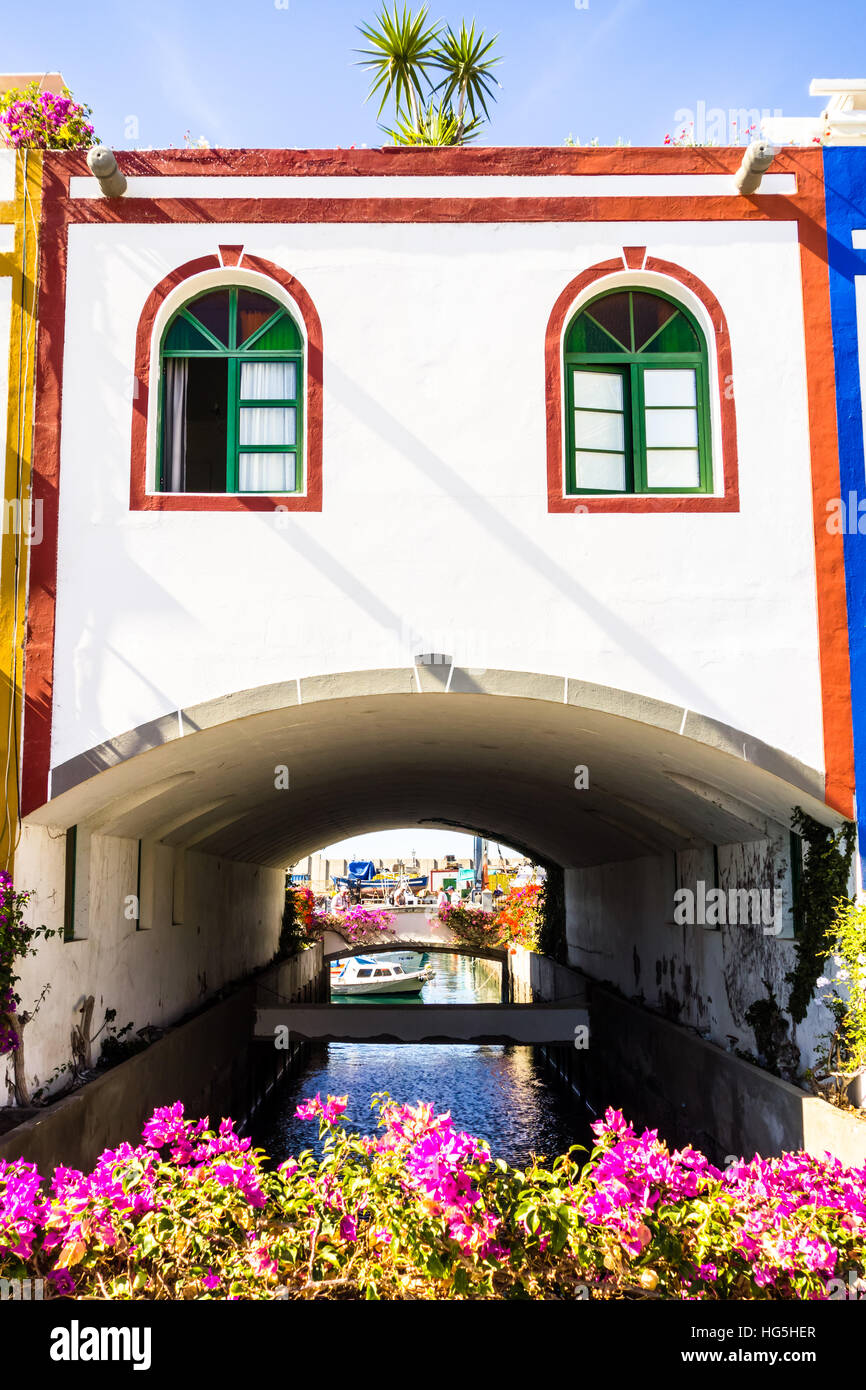 Ein einzigartiges Gebäude, geformt wie eine Brücke über einen Kanal in Puerto De Mogan, ein kleiner Fischerhafen auf Gran Canaria. Stockfoto