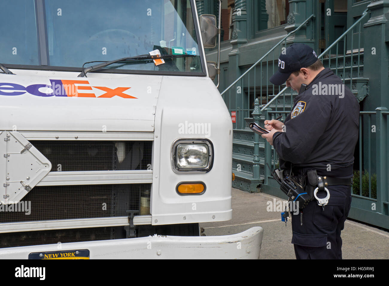Ein Polizist der Soho-Abschnitt der unteren Manhattan, New York City eine Parkkarte für einen Fedex LKW schriftlich Stockfoto