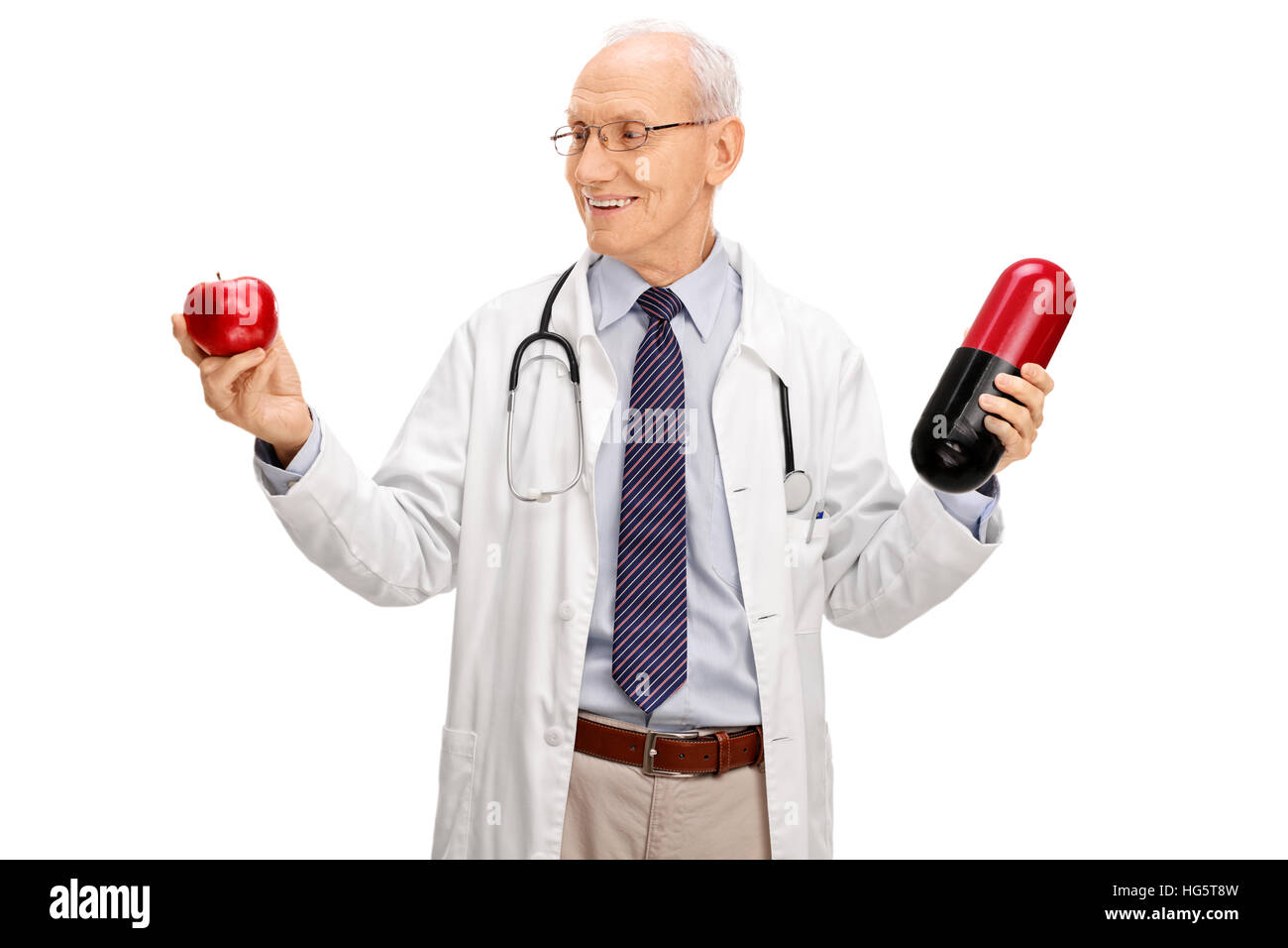 Versucht Reife Arzt hält einen Apfel und eine große Pille isoliert auf weißem Hintergrund Stockfoto