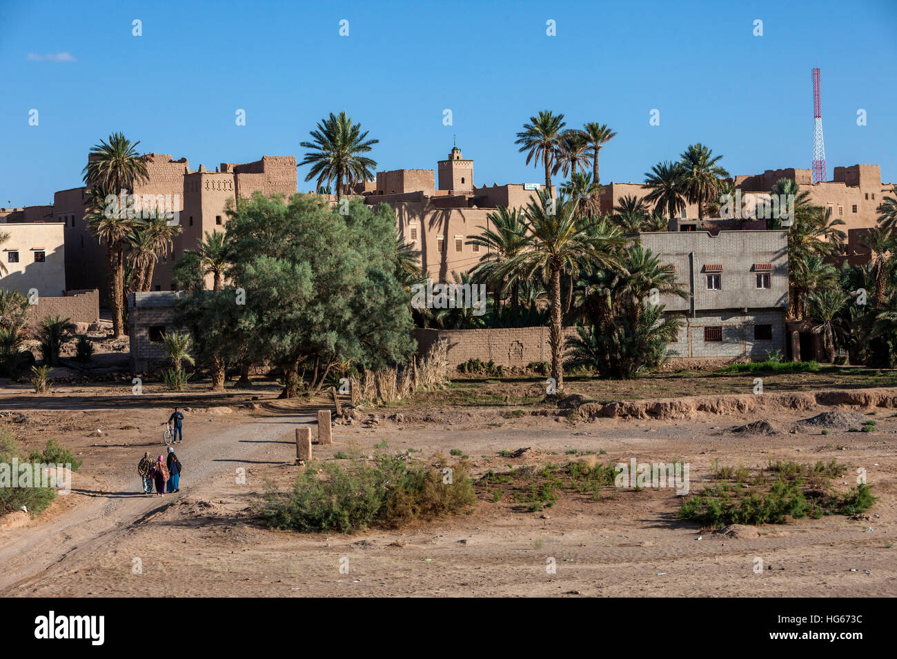 Ksar Elkhorbat, Marokko.  Straße führt an der Kasbah im Hintergrund, jetzt ein Hotel für Touristen.  Cell Phone Tower auf rechten Seite. Stockfoto