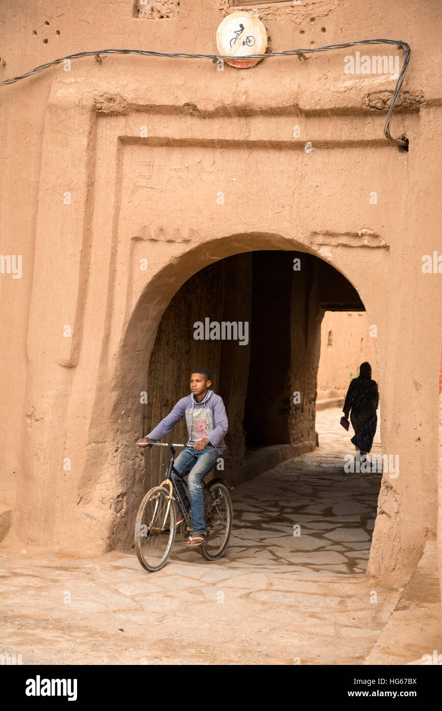 Ksar Elkhorbat, Marokko.  Jungen Fahrrad von Casbah, Radfahren verboten Schild über dem Eingang. Stockfoto