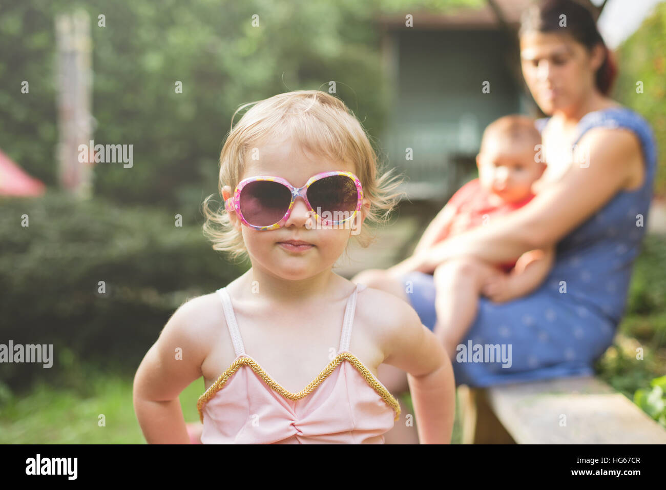 Porträt einer jungen Tochter, die ihre Mütter Sonnenbrille im Garten hautnah Stockfoto