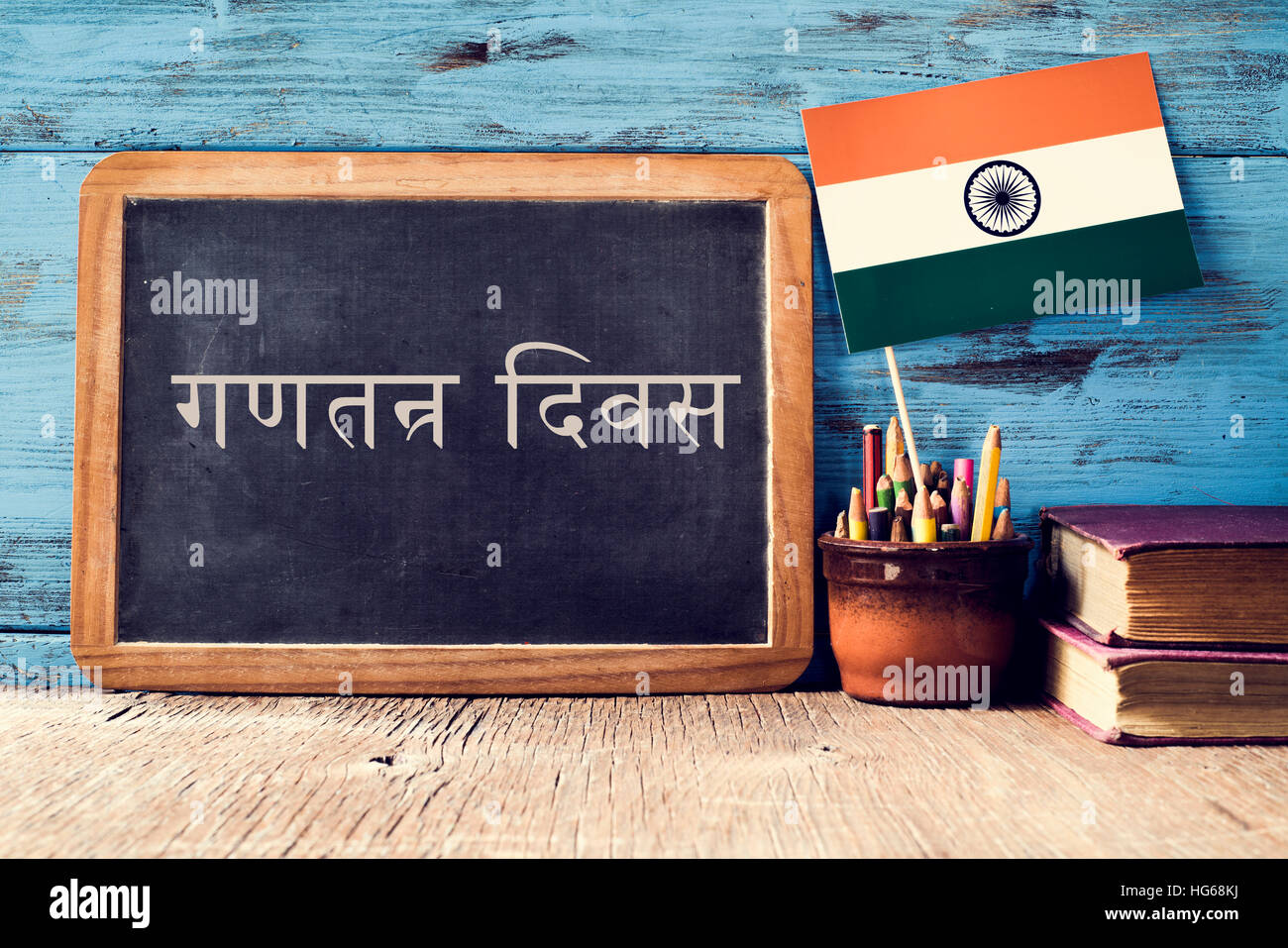 eine Tafel mit dem Text Republic Day geschrieben in Hindi und eine Fahne von Indien, auf einer rustikalen Holzoberfläche auf blauem Grund aus Holz Stockfoto