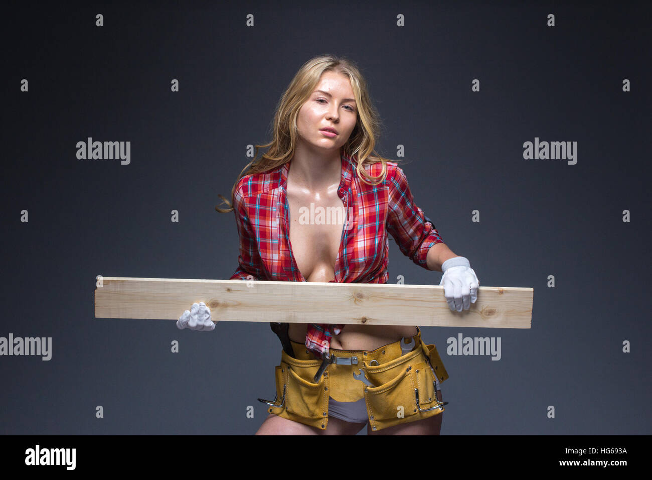 Porträt der jungen weiblichen Bau Schreiner Arbeiter mit Bleistift und Holzbrett auf Arm Stockfoto
