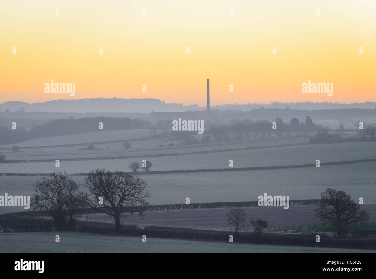 Lange Itchington, in der Nähe von Leamington Spa, Warwickshire, UK. 5. Januar 2017. Einem kalten frostigen Start in den Tag mit einer Temperatur von - 5.5ºC in ländlichen Warwickshire. Die Cemex Schornstein gegen einen farbenfrohen Sonnenaufgang. © Dan Tucker/Alamy Live-Nachrichten Stockfoto