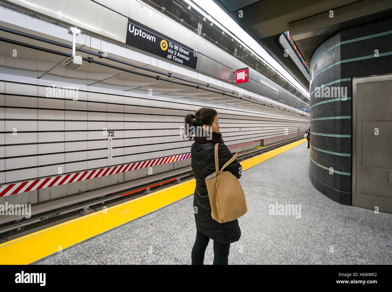 Eine asiatische Frau wartet ein Uptown Zug an der 72nd Straße Station der Second Avenue U-Bahn in New York City Stockfoto