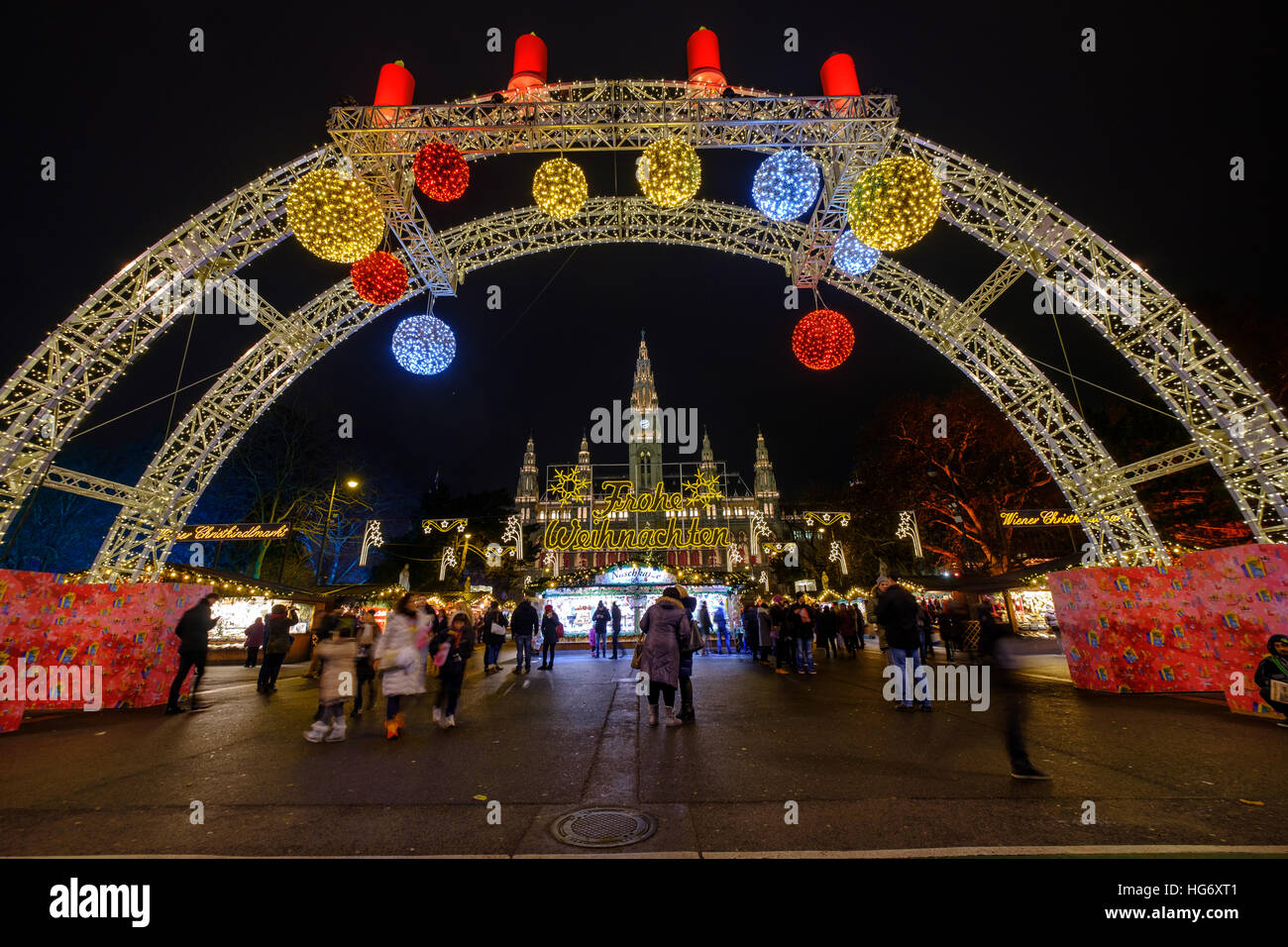 Menschen besuchen den Weihnachtsmarkt in der Nähe von Rathaus am Abend Stockfoto