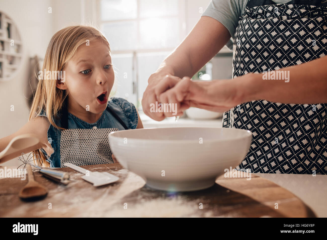 Aufgeregt, junges Mädchen mit Mutter backen Teig vorbereiten. Frau die Hände mit Tochter stehen in der Küche kochen. Stockfoto
